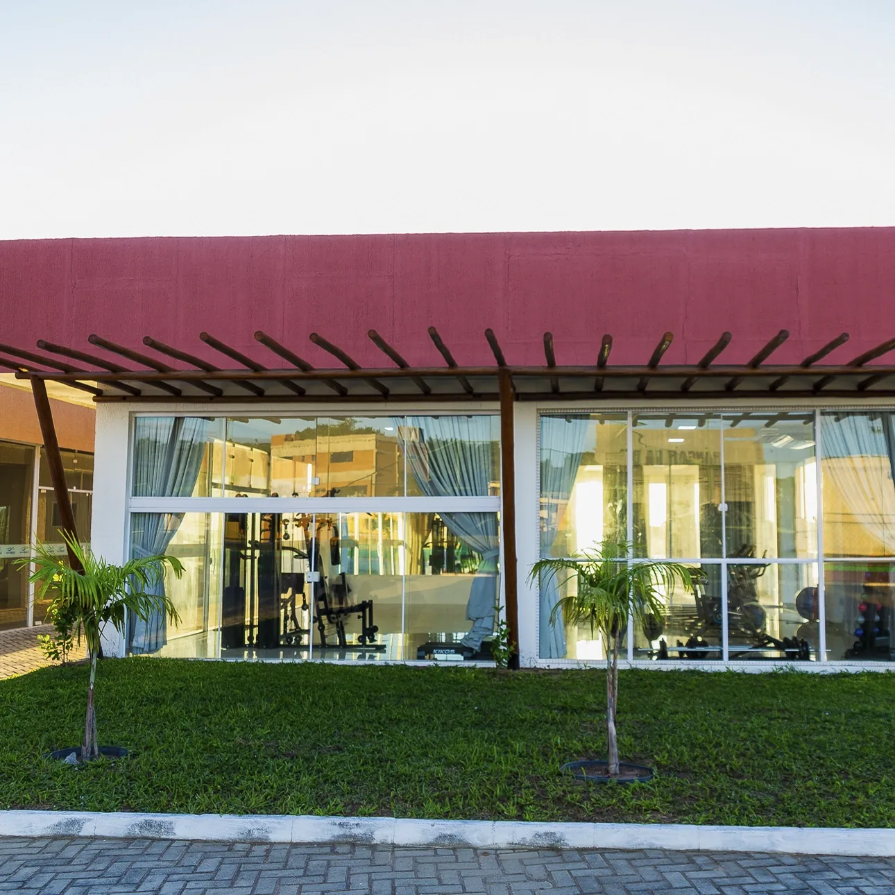 Academia com fachada de vidro e equipamentos de musculação
