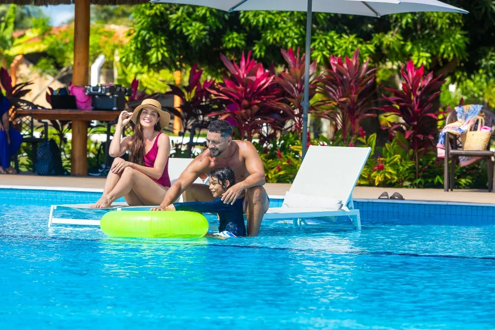 Família na borda da piscina do condomínio